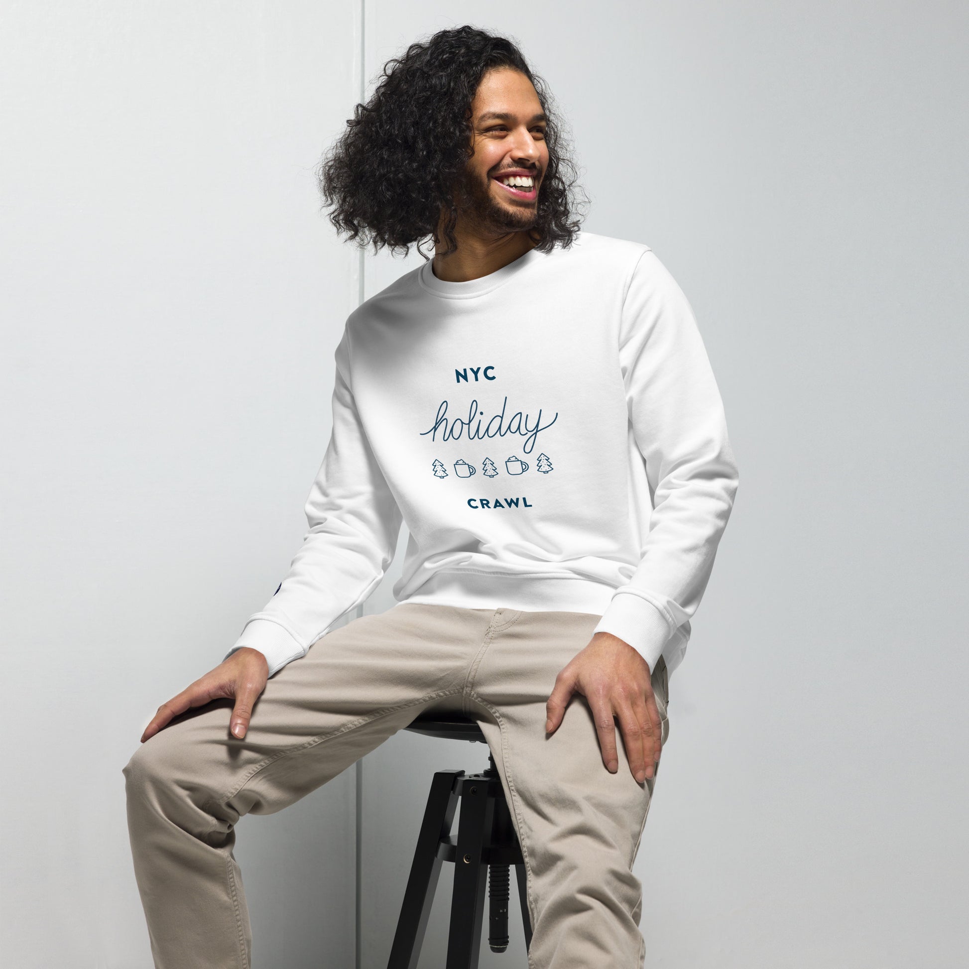 NYC holiday crawl navy design Unisex White Crewneck Sweatshirt Adult Man Sitting. City Crawl Adventures.